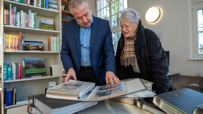 Landrat Michael Geisler, der selbst in Struppen lebt, blättert mit Heidi Schweizer durch die 19 Bände der Ortschronik Struppen, die dem Archivverbund Pirna übergeben wurde.