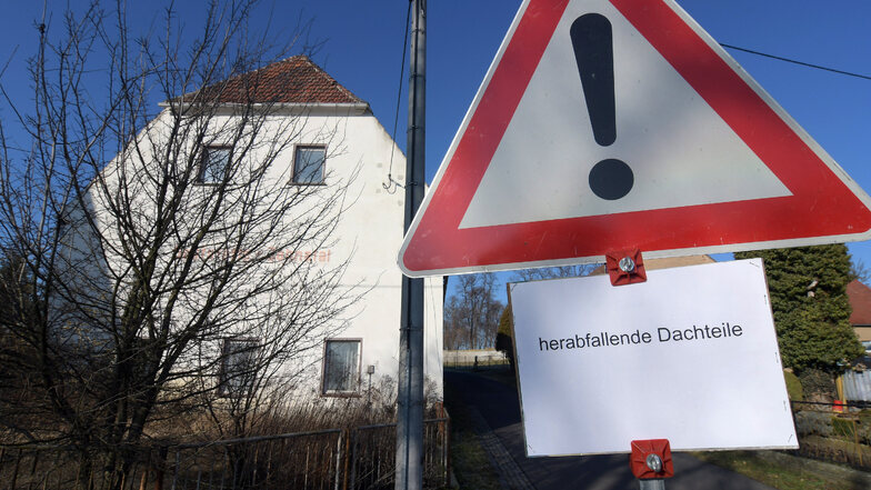 Seit Januar warnt dieses Schild Fußgänger und Autofahrer vor herabfallenden Gebäudeteilen. Nun wird das Objekt notgesichert.