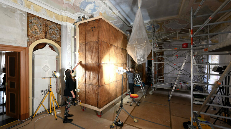Die 300 Jahre alte Ledertapete wird von der Wand abgenommen und auf einen Kasten aufgespannt. Die Restauratoren Franziska Wosnitza (links) und Anna Siegel begutachten die Schadstellen.
