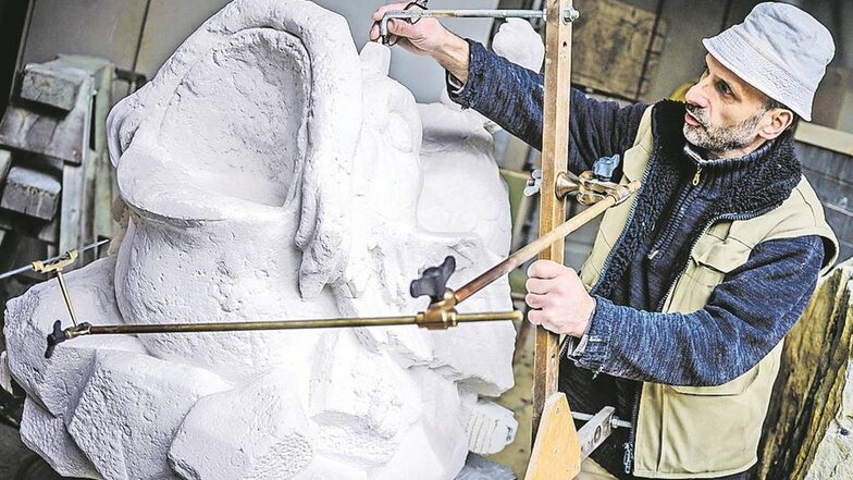 Hans-Christoph Pampel nimmt die Maße am Gipsabguss eines Delfins. Mit dem Punktiergerät wird sie der Bildhauermeister auf einen Sandsteinblock übertragen. So kann eine Kopie des Kunstwerks am Brunnen des Nymphenbades gefertigt werden.
