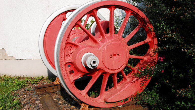 Kleine Modelle und ein großes Rad. Dieses Rad gehörte einst zu einer Dampflok und ist in Großkagen zu sehen.