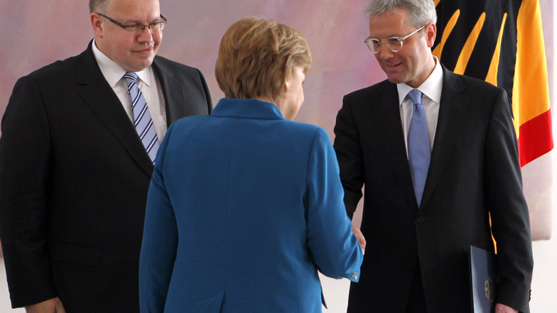 Angela Merkel (CDU) gibt nach der Ernennung des neuen Umweltministers Peter Altmaier im Mai 2012 Norbert Röttgen die Hand.
