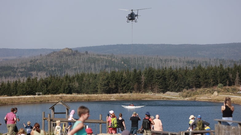 Ein Hubschrauber nimmt am Rückhaltebecken am Torfhaus bei Schierke Wasser für die Waldbrandbekämpfung am Brocken auf.