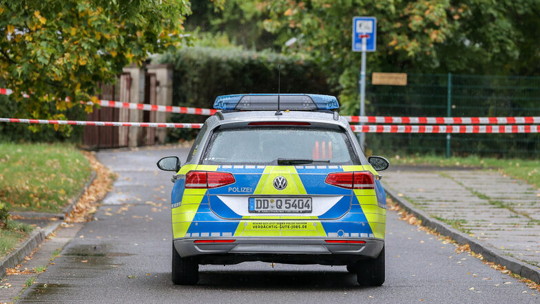 Ein Polizeifahrzeug steht an einer Absperrung im Leipziger Stadtteil Paunsdorf. Die Polizei sucht mit einem Großeinsatz nach einem Mann, der mehrfach versucht haben soll, Kinder zu entführen.
