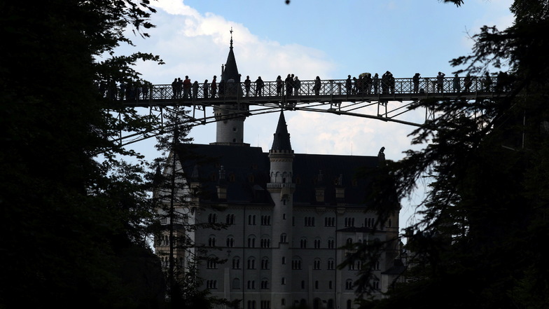 Touristen stehen auf der Marienbrücke vor dem Schloss Neuschwanstein. In der Nähe wurden zwei Touristinnen in eine Schlucht gestoßen.