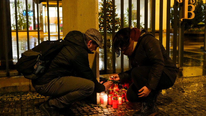 Eine Frau entzündet Kerzen vor dem Gebäude der Philosophischen Fakultät der Karls-Universität in der Prager Innenstadt.