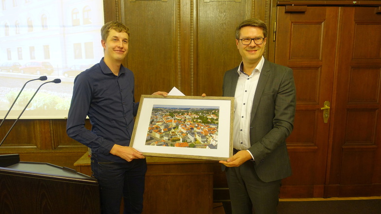 Von Oberbürgermeister Sven Liebhauser (rechts) hat Christoph Klix ein Luftbild von Döbeln für sein künftiges Büro bekommen.