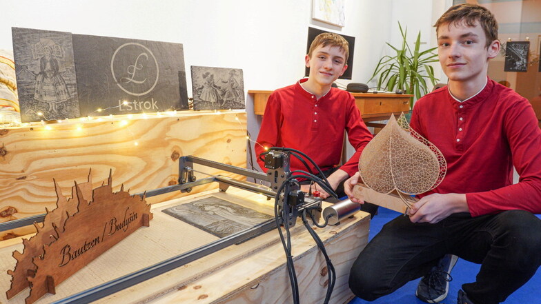 Beno Cemjer (l.) und Jakub Schneider haben ihre eigene Firma. Mit einem Laser gravieren die Achtklässler in Panschwitz-Kuckau Schieferplatten und schneiden Motive aus Holz.