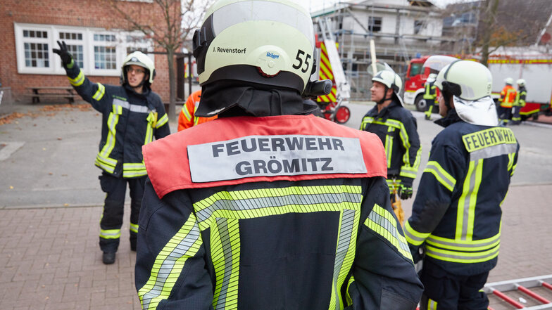 Die Mitglieder der Freiwilligen Feuerwehr Grömitz nehmen an einer Ausbildung auf dem Gelände der Grundschule teil.