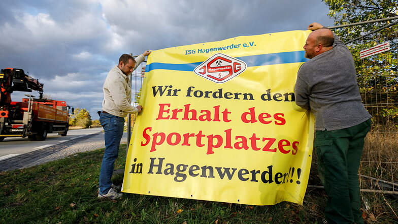 Michel Koch (links) und Andreas Zimmermann brachten 2018 an der B 99 in Hagenwerder ein Transparent für den Erhalt des Sportplatzes an.