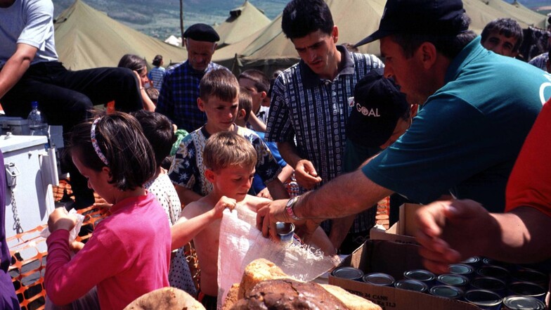Hilfsorganisationen verteilen im Jahr 1999 Essen an die Flüchtlinge im nordalbanischen Kukes an der Grenze zum Kosovo (Jugoslawien).
