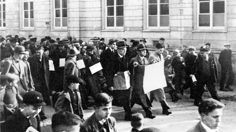 Bautzen am 10. November 1938: Juden werden durch die Schulstraße getrieben. Die Schmähschriften auf den Plakaten wurden im Nachhinein retuschiert, so dass sie nicht mehr lesbar sind. Quelle: Museum Bautzen/Anonymer Fotograf
