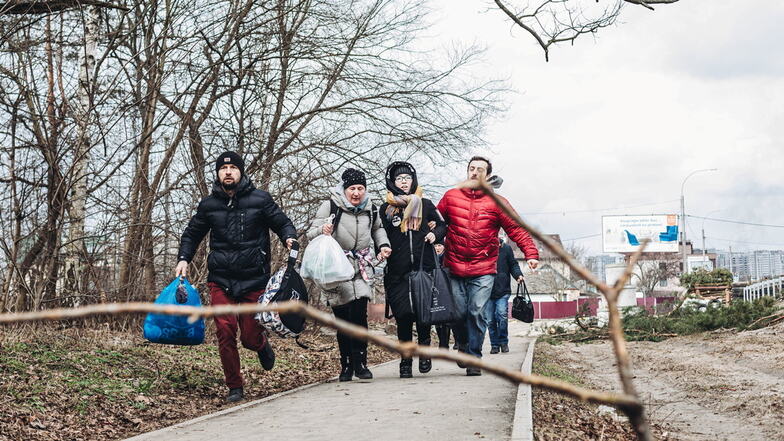 Viele Ukrainer sind auf der Flucht, um sich vor den Kämpfen in Sicherheit zu bringen. Eine Familie rennt vor dem Beschuss der Stadt Irpin weg.