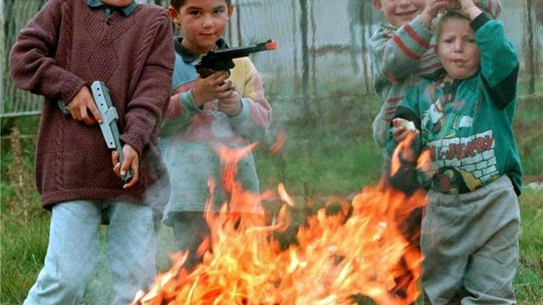 Albanischstämmige Kinder aus dem Kosovo spielen Ende Oktober 1998 mit Spielzeuggewehren nach der Rückkehr in das Dorf Komorane. Zuvor hatten sich die Einwohner des Dorfes im nahe gelegenen Wald vor den jugoslawischen Soldaten versteckt.