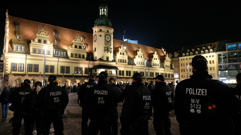 Polizisten stehen am Freitagabend auf dem Leipziger Marktplatz zwischen einer Kundgebung von "Querdenkern" sowie einer Gegendemonstration.