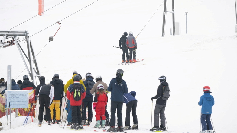Wintersportler warten am Fuße des Skigebiet Erlebnisberg Altenberg an einem Skilift. Nach reichlich Neuschnee läutet Sachsen die Skisaison ein.