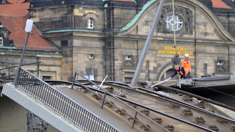 Fachleute begutachten den Brückenzug neben dem eingestürzten Zug: Auch dieser ist wahrscheinlich beschädigt.