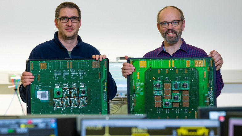 Das wird gebraucht, bevor neue Mikrochips fürs Auto in Serie gehen können: Testingenieur Jörg Peter (links) und Standortleiter Dr.-Ing. Thomas Leitner halten Boards zum Prüfen von Schaltkreisen im Unternehmen DMOS in Dresden.