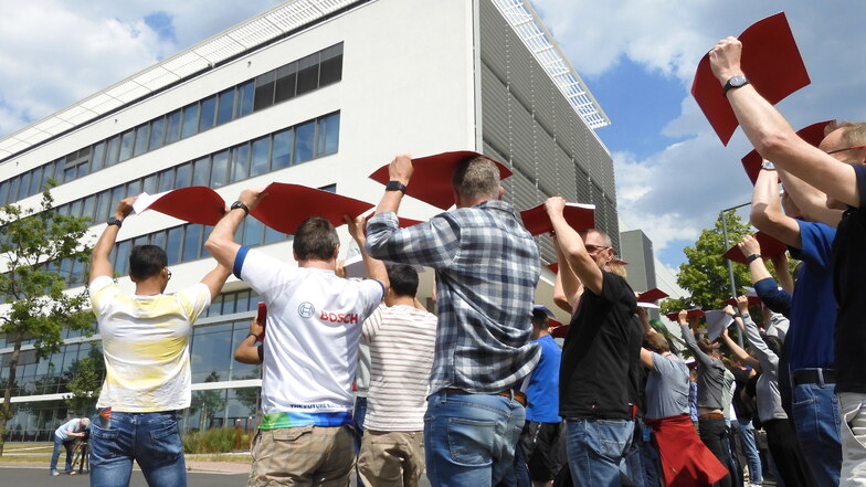 Demo mit roten und weißen Pappen: Vor der Mikrochipfabrik formen Bosch-Beschäftigte gemeinsam Zahlen.