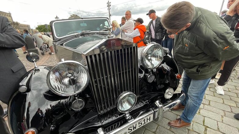 Schaulustige bestaunen das Auto, einen Rolls-Royce Silver Wraith.