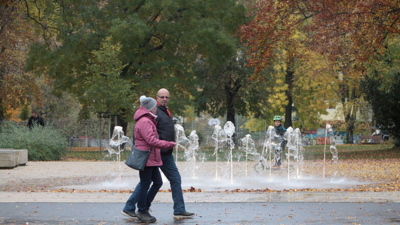 Zwei Passanten laufen am Friedenspark in Pirna vorüber. Nach der tödlichen Messerattacke fordern Anwohner mehr Sicherheit und Kontrollen.