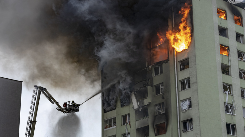 Feuerwehrleute löschen einen Brand in einem 12-stöckigen Mehrfamilienhaus, das durch eine Gasexplosion schwer beschädigt wurde.