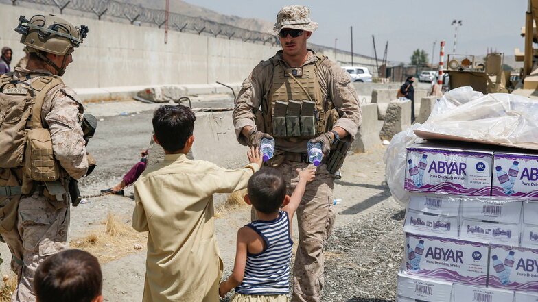 Auf diesem von den US-Marines zur Verfügung gestellten Bild verteilt ein US-Marinesoldat während einer Evakuierung Wasser an Kinder.