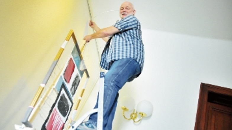 Rainer Belan beim Aufhängen der Ausstellung im Rathaus.
