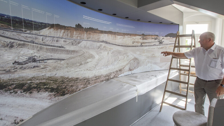 Im Mügelner Geoportal (Besucherzentrum) erfahren Besucher alles über den historischen, aber auch den aktuellen Kaolinabbau. Hier zeigt Mügelns Bürgermeister Johannes Ecke ein riesiges Panoramabild vom heutigen Tagebaugelände.