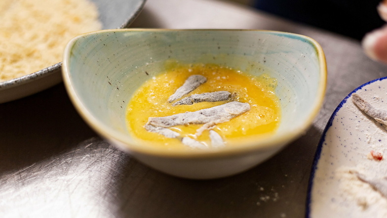 Bevor die Fische mit fernöstlichen Panko-Brotbröseln paniert werden, dürfen sie noch einmal schwimmen - in Ei.