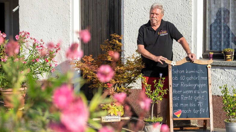 Gerd Lorkowski in seinem Großenhainer Grundstück an der Tafel im Hof. Hier bringt er die Leute zum Schmunzeln und Nachdenken.