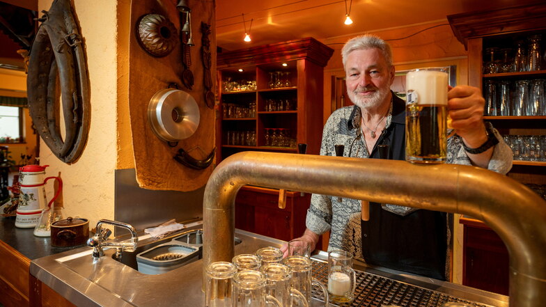 Jürgen Przybyl zapft das Bier in der Bauernschänke Röhrsdorf, während sein Sohn in der Küche steht.