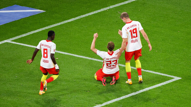 Leipzigs Marcel Halstenberg (M) und Amadou Haidara (l) sowie Hannes Wolf jubeln nach Halstenbergs Treffer zum 4:0-Endstand von RB gegen Schalke 04..