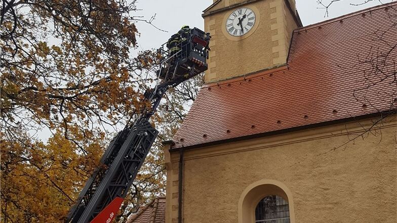 Mit der Drehleiter der Feuerwehr sollte die umgeknickte Wetterfahne vom Kirchturm geholt werden – doch alle Versuche scheiterten.