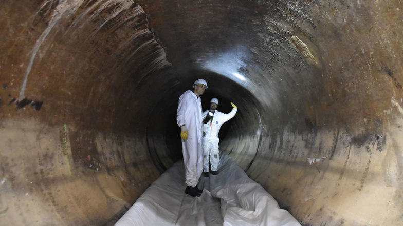 Der erste Schlauch ist im Abwassertunnel. Die Kanalsanierer Frank Grüssing (vorn) und Eric Ulrich begutachten die 113 Jahre alte Röhre, bevor die Schläuche mit Wasserdruck gegen die Wand gepresst werden.