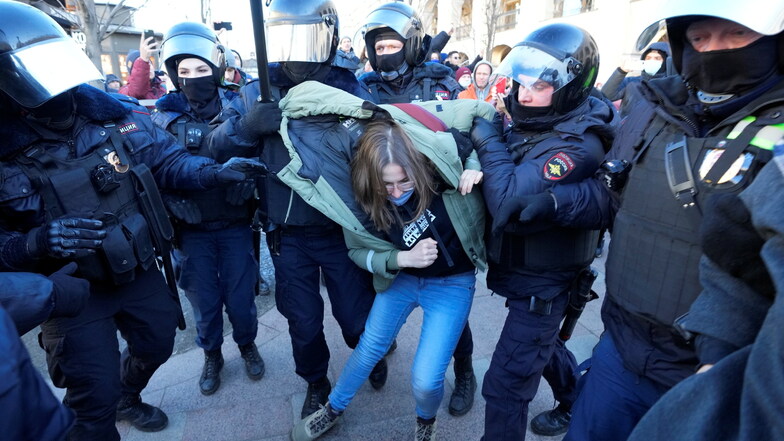 Russland, St. Petersburg: Die Polizei nimmt eine Demonstrantin während einer Aktion gegen Russlands Invasion in die Ukraine fest. Trotz Massenverhaftungen gingen die Menschen in Moskau, St. Petersburg und anderen russischen Städten den dritten Tag in Folg