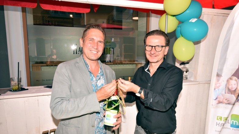 Jan Schulze, Geschäftsführer der Breitband Hoyerswerda GmbH (li), überreichte Heiko Schneider gestern eine Flasche Sekt mit einer Schleife aus Glasfaserkabel.