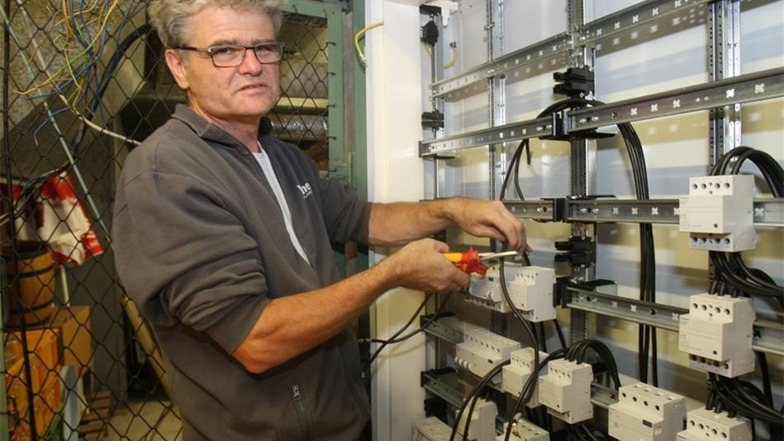 Elektriker Georg Kühne verkabelt neue Schaltschränke im Keller.