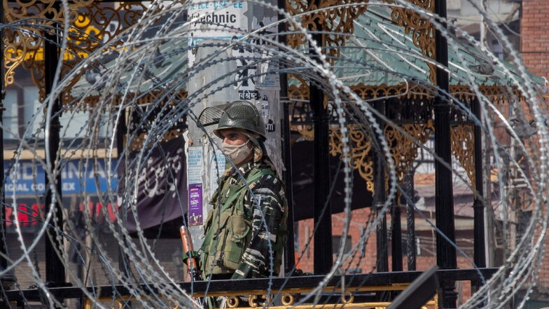Ein paramilitärischer Soldat steht vor einem geschlossenen Markt. Nach dem Tod eines bekannten Separatistenführers in der indischen Unruheregion Kaschmir an der Grenze zu Pakistan, hat die Regierung das Internet gesperrt sowie das Mobilnetz und die Bewe