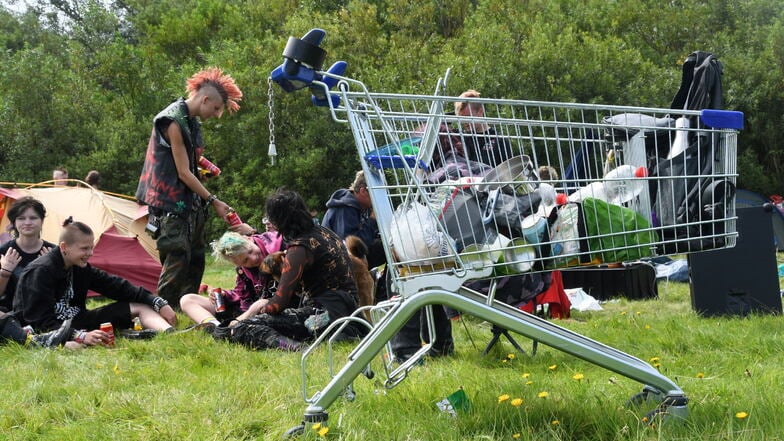 Teilnehmer des Punk-Protestcamps auf Sylt sitzen auf der Camp-Wiese von "Aktion Sylt".