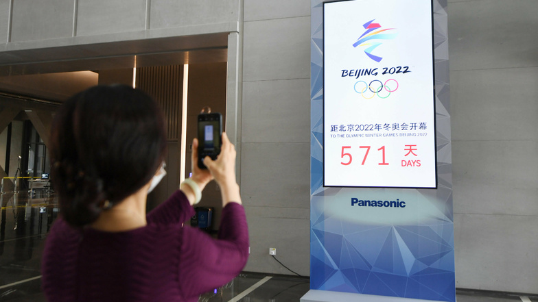 Eine Frau fotografiert eine Countdown-Anzeige für die Olympischen Winterspiele in Peking 2022