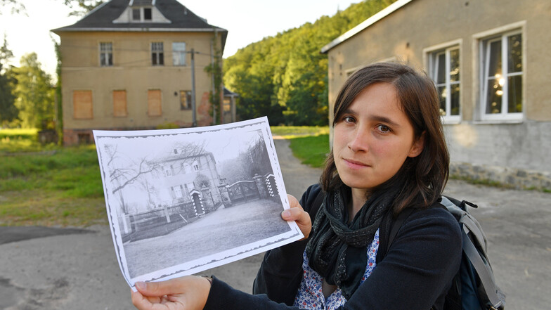 Die Kommandantenvilla des ehemaligen KZ Sachsenburg ist mittlerweile verfallen. Auf diesem Foto aus dem Jahr 2017 hält Gymnasiallehrerin Anna Schüller ein historisches Bild der Villa in Händen.