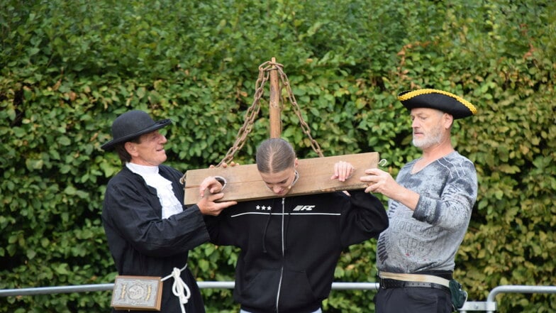 Am Pranger bei den Königshainer Sagenspielen: Der Königshainer Bürgermeister Maik Wobst (rechts im Bild) und Michael Fiebiger als Pfaffe proben, wie "Franziska“ am besten in den Schandpfahl passt.