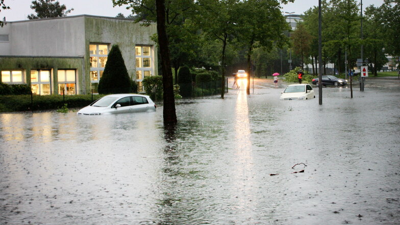 Zwei Autos stehen am 28.07.2014 auf einer überfluteten Straße in Münster (Nordrhein-Westfalen). Heftige Regenfälle waren damals über der Stadt niedergegangen.