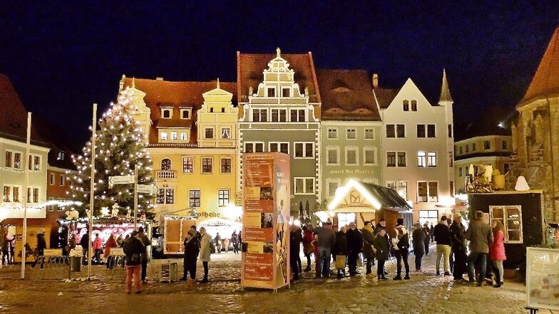 Sonnabendabend auf dem Meißner Markt. Buden um den Weihnachtsbaum bieten Kunsthandwerk und Weihnachtsleckereien. Die Gasthäuser verkaufen Glühwein to go.