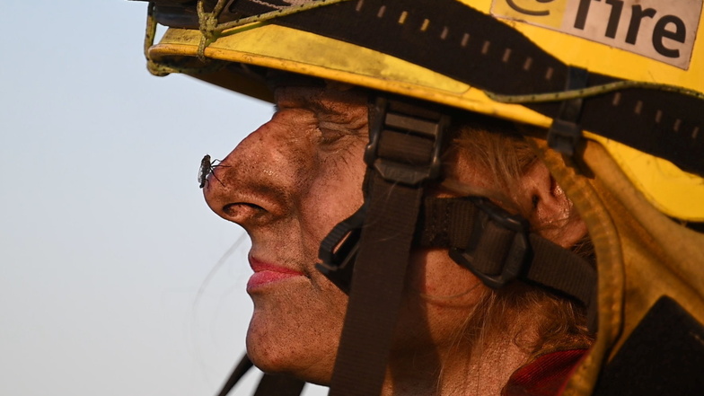 Julia Richardt, freiwillige Feuerwehrfrau bei dem Internationalen Katastrophenschutz Deutschland "@fire" kämpft in der Sächsischen Schweiz gegen die Feuer. Ihr Gesicht ist vom Ruß verschmutzt.