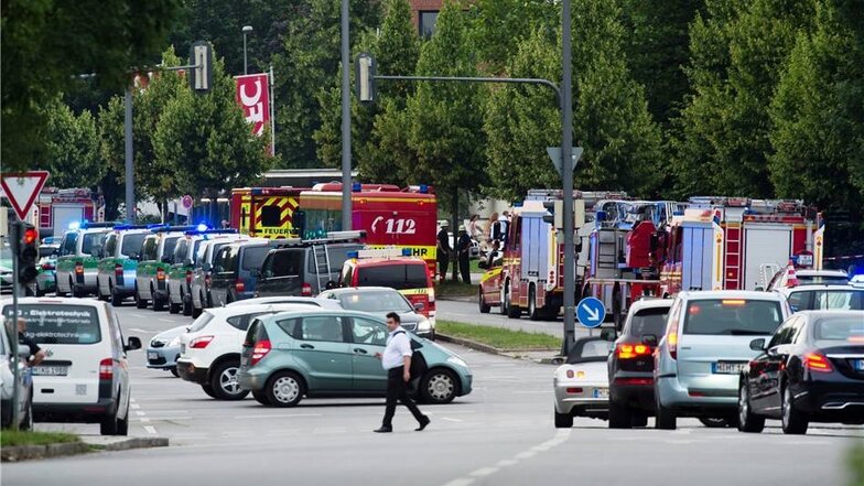 Fahrzeuge von Feuerwehr und Polizei stehen am Freitagabend in München auf der Zufahrt zu dem Einkaufszentrum, in dem Schüsse gefallen sind.