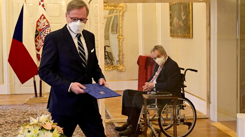 Petr Fiala (l) wurde auf Schloss Lany von Miloš Zeman (re) als neuer Ministerpräsident des Landes vereidigt. Bei der Zeremonie trennte beide eine durchsichtige Wand, da Zeman positiv auf das Coronavirus getestet wurde.