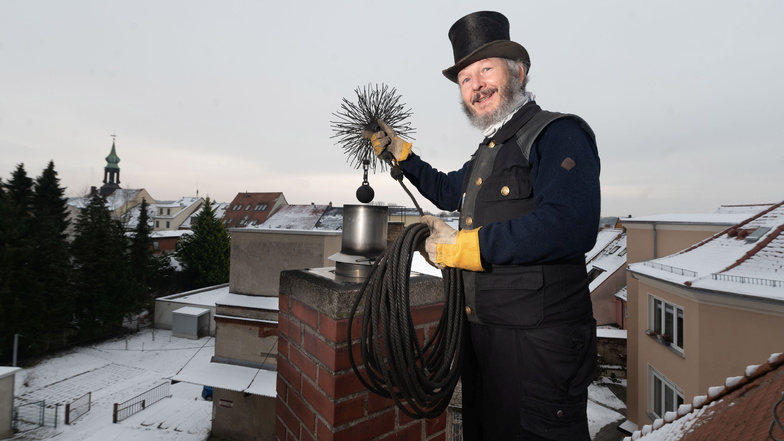 Matthias Hänsel in typischer Schornsteinfegermontur auf dem Haus seines Daches in Radeberg.