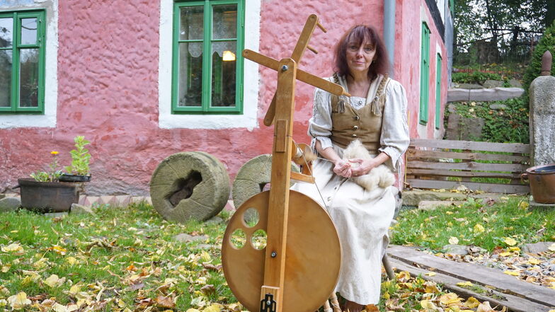 Renata Šoltová am Spinnrad vor ihrem Haus in Krásný Les (Schönwald). Von der Schafwolle bis zum Kleidungsstück entsteht alles in traditioneller Handarbeit.
